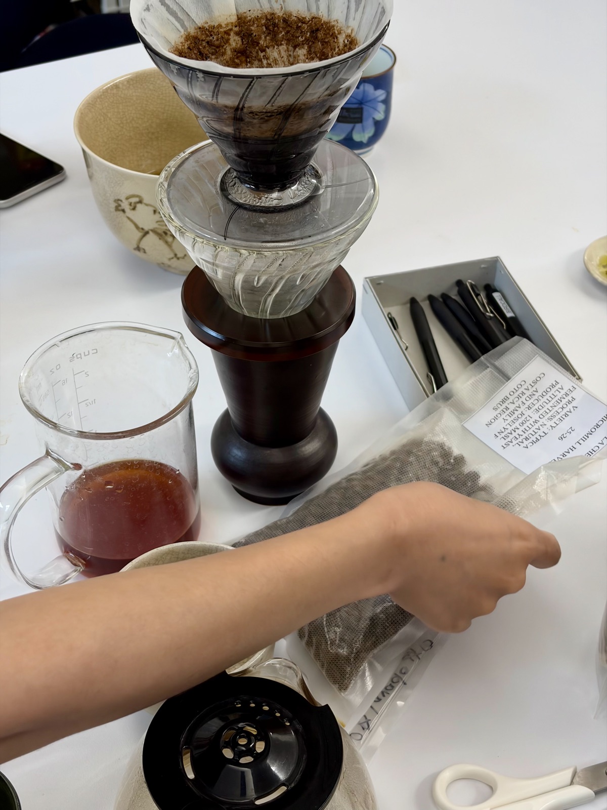Hand drip coffee gear laid out — a dripper and server alongside a bag of Costa Rican beans 핸드드립 드리퍼와 커피 서버, 코스타리카 원두 패키지 등 커피 추출 도구들이 놓여 있는 모습