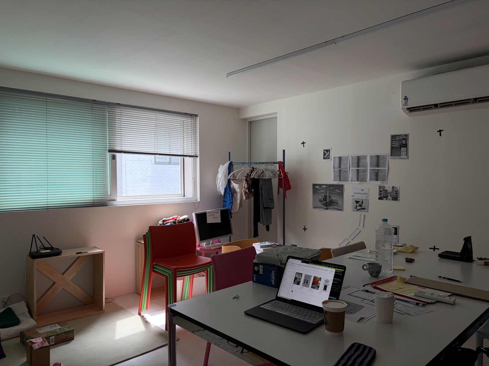 A work desk with a laptop and documents at Seoul Reading Room, Sinchon Munhwagwan studio 8. 신촌문화관 8호실에 자리한 서울리딩룸. 노트북과 자료가 놓인 작업용 책상과 실내 작업 공간.