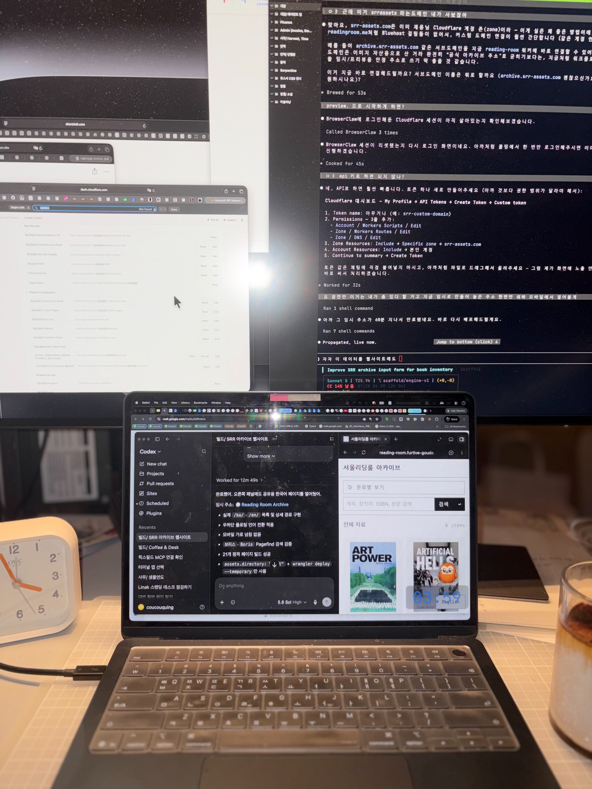 Monitors, a laptop, a desk clock, and iced coffee. 모니터와 노트북, 탁상시계, 아이스 커피