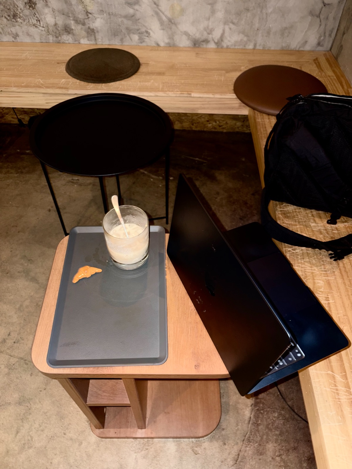 A workspace with a laptop, an iced latte, and a spoon rest on a cafe table 카페 테이블 위에 노트북과 아이스 라떼, 숟가락 받침이 놓여 있는 작업 공간