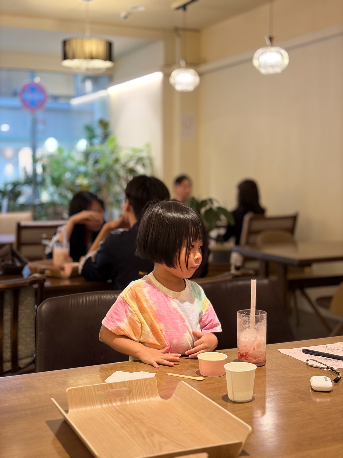 Ether sitting at a table with a strawberry drink in front of her in a warm, cozy cafe 따뜻한 분위기의 카페에서 딸기 음료를 앞에 두고 테이블에 앉아 있는 이서