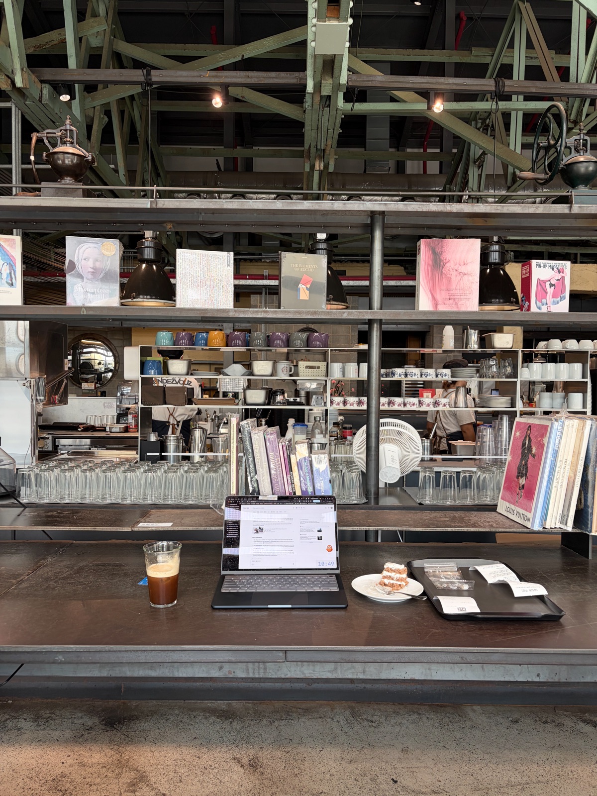 Laptop work in a cafe lined with books and ceramics. 책과 도자기가 놓인 카페에서의 노트북 작업.