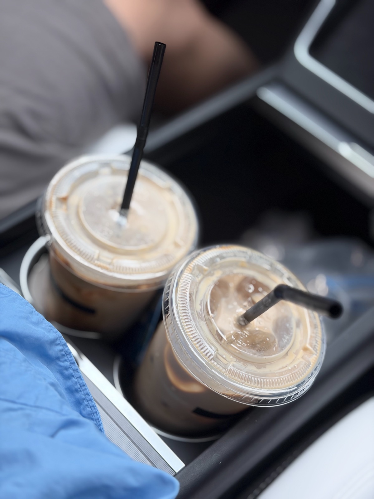 Two iced lattes in a car cup holder 차량 컵홀더에 놓인 아이스 라떼 두 잔