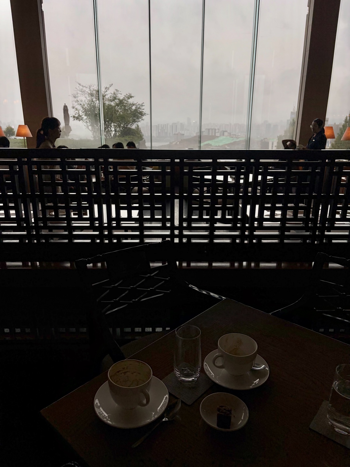 A city view beyond the glass wall, a coffee cup on the table 통창 너머 시티뷰와 테이블 위 커피잔
